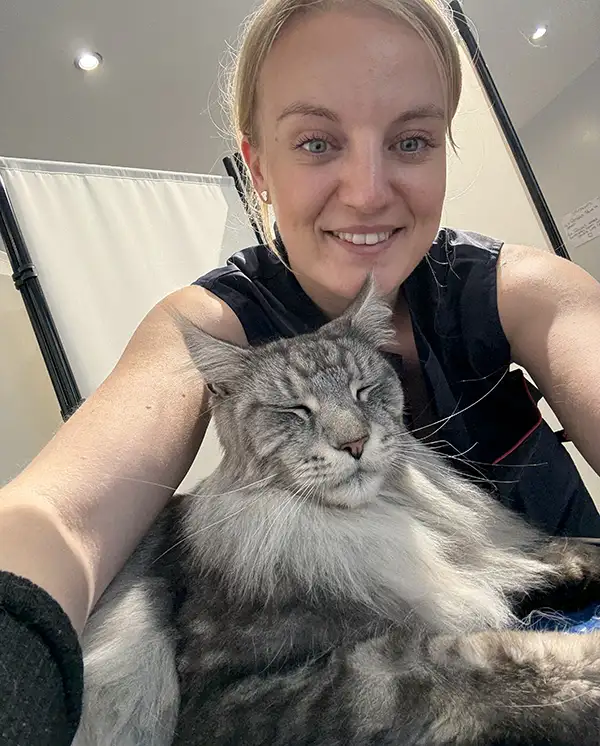 Emma -Whiskers retreat Cat groomer Southampton Emma cuddling a relaxed grey cat. Whiskers retreat Cat groomer Southampton